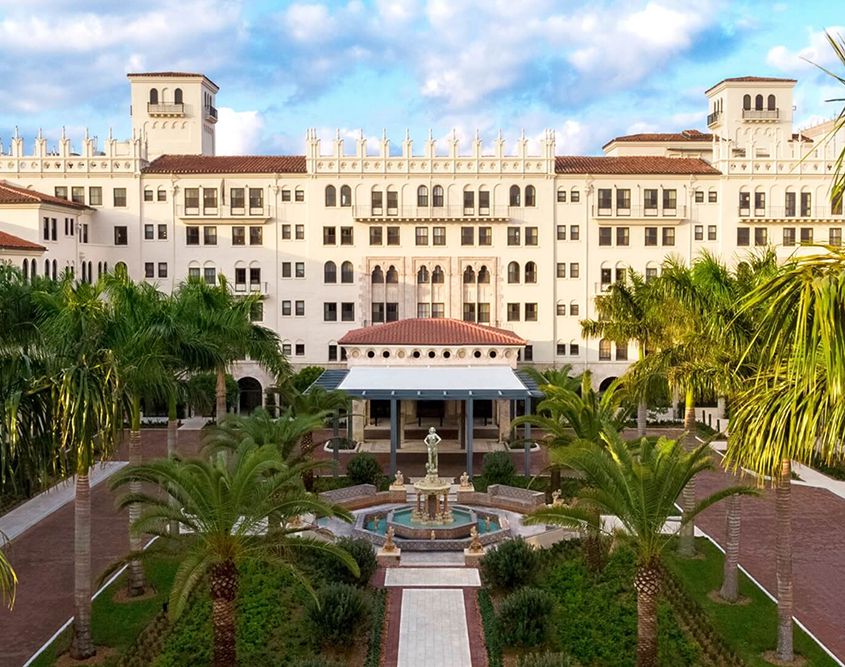 The Boca Raton's main building and fountain courtyard lined with palm trees