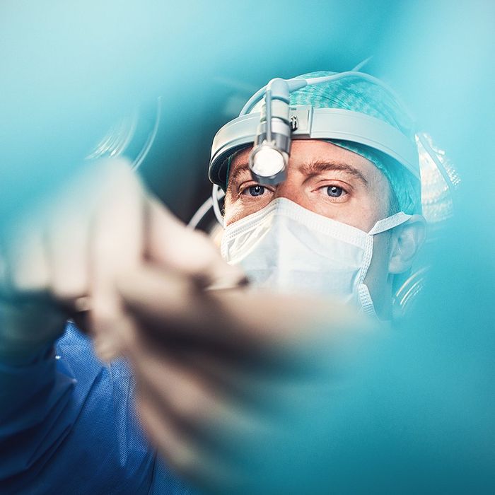 Surgeon wearing a headlight and mask during a procedure