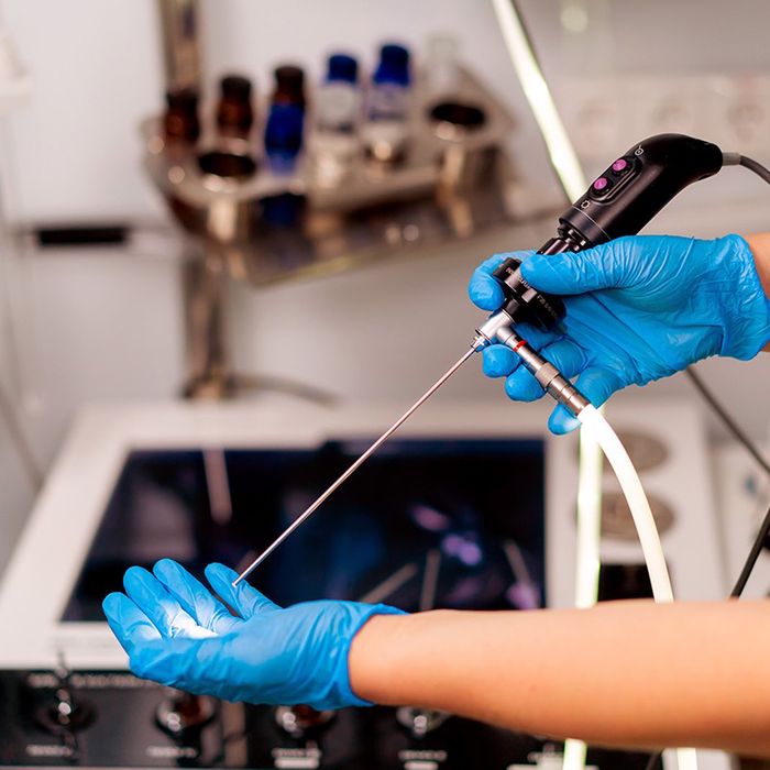 Gloved hands holding a surgical endoscope in the cadaver lab